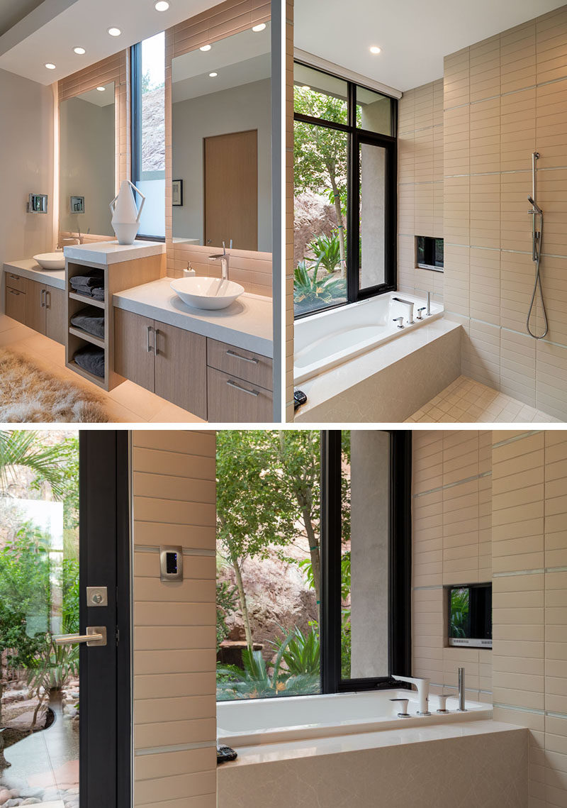 In this master bathroom, floor-to-ceiling tiles cover the walls and dual vanities makes sure there's plenty of counter space and storage. The bathroom also opens to a small private patio surrounded by plants. #ModernBathroom #MasterBathroom #BathroomDesign