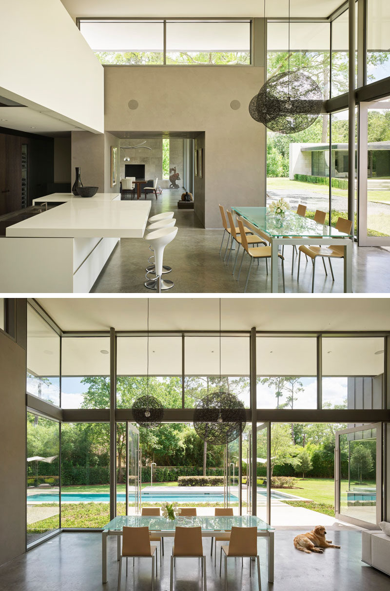 At the heart of this modern house is a double-height great room encompassing family living, a dining area and kitchen. #ModernInterior #HighCeilings #PivotDoors