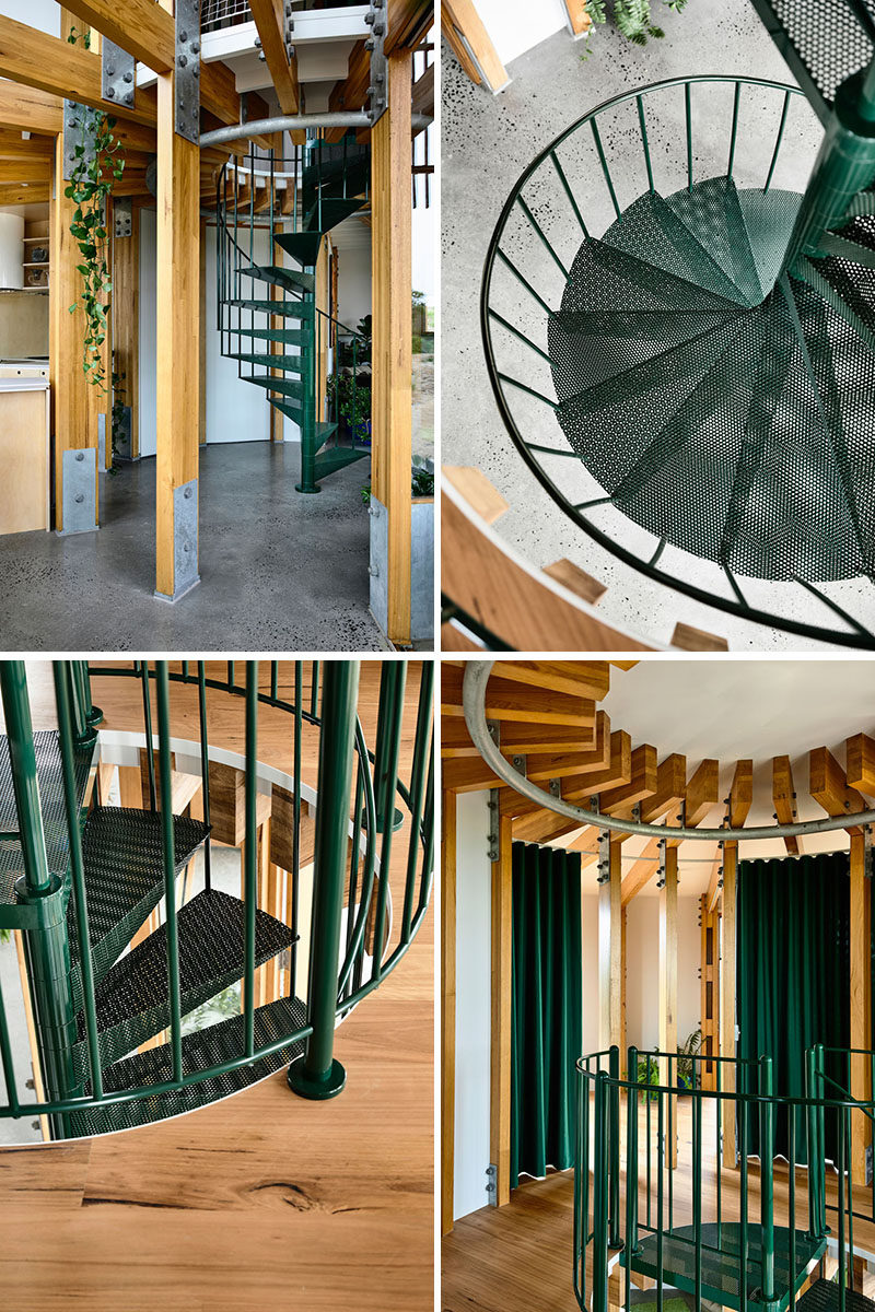 A dark green metal spiral staircase connects the two floors of this modern circular beach house. #SpiralStairs #SpiralStaircase