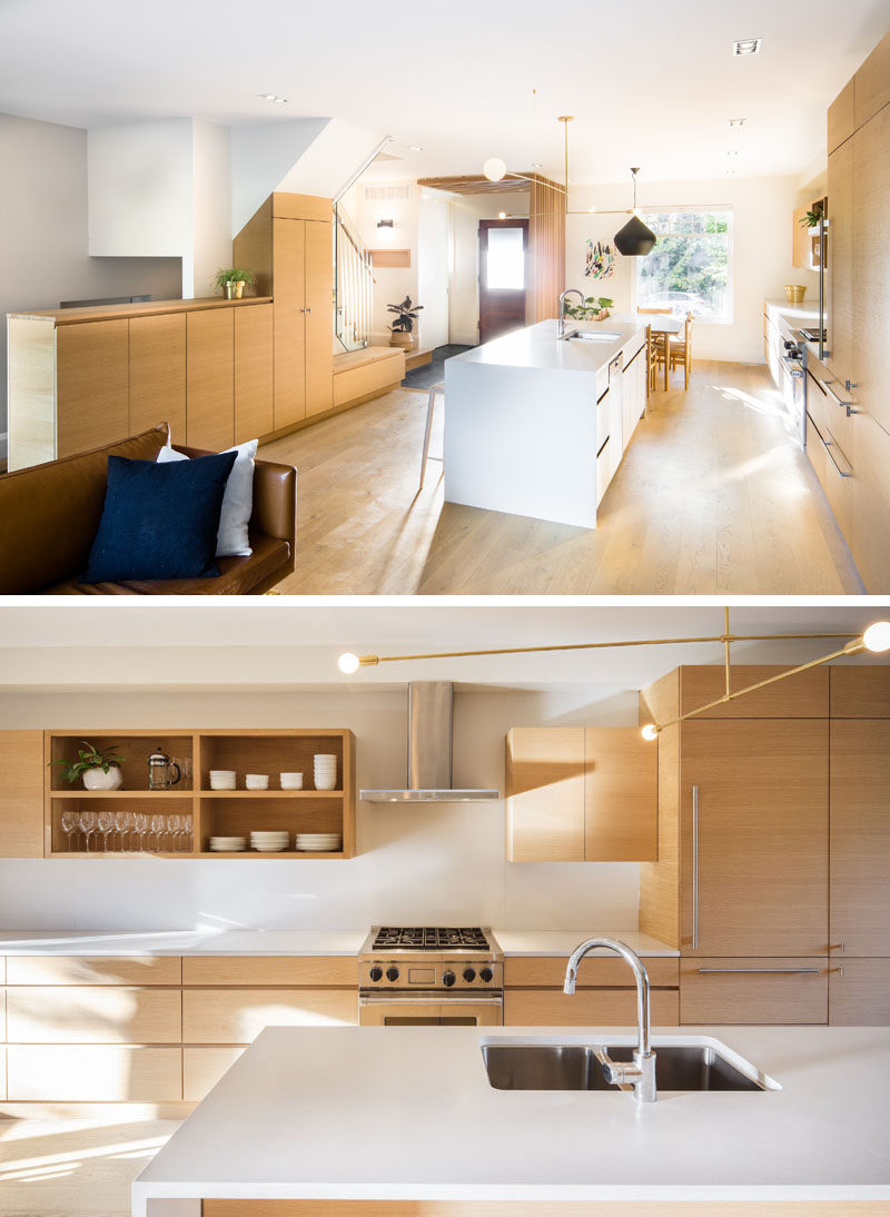 The main floor of this renovated house has been opened up and dedicated to the social areas, like the dining room, kitchen, and living room. Custom millwork was added to create a uniform look throughout the house. #KitchenDesign #WoodAndWhiteKitchen #ModernKitchen