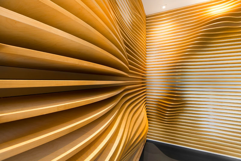 Baran Studio have designed a sculptural accent wall, made from CNC cut plywood, for the lobby of a building in California. #WoodAccentWall #WoodWall #AccentWall #OfficeDesign