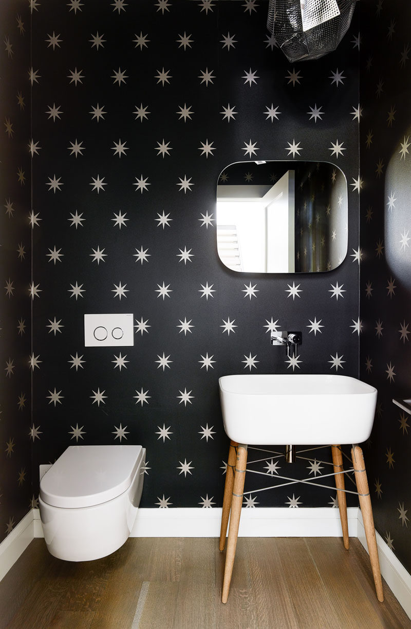 In this modern bathroom, black and white wallpaper covers the walls to a create a fun and unexpected look. #SmallBathroom #BathroomDesign