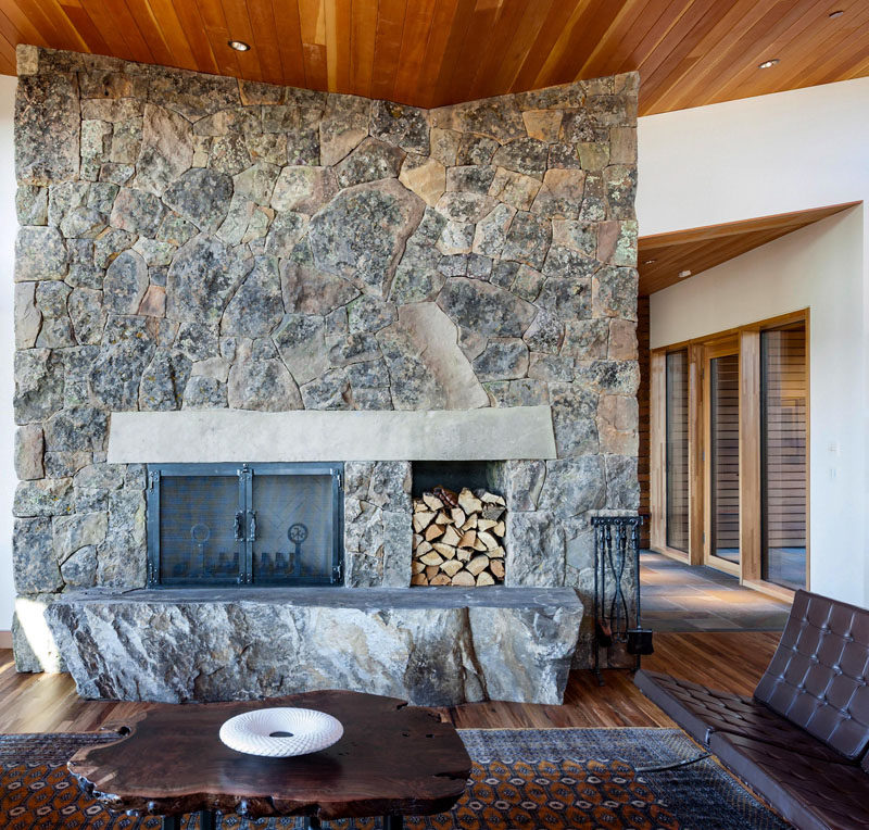 A single slab of stone serves as the hearth and another as the mantle to this contemporary house's wood-burning fireplace. #Fireplace #StoneFireplace #LivingRoom