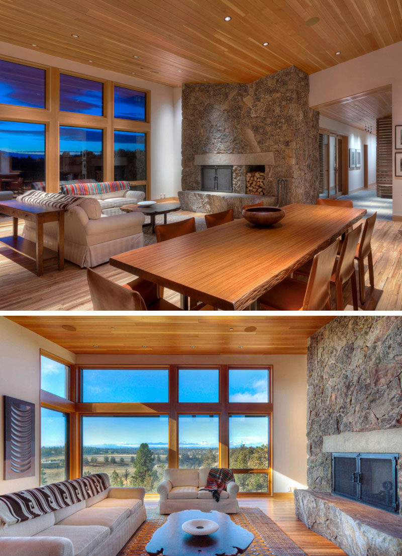 The open-plan interior of this contemporary home features natural materials, a dining area with a  sustainably harvested Sapele wood dining table sporting its live edge, and wood floors throughout the home that came from hardwoods salvaged from shipping crates. #LivingRoom #DiningRoom #StoneFireplace