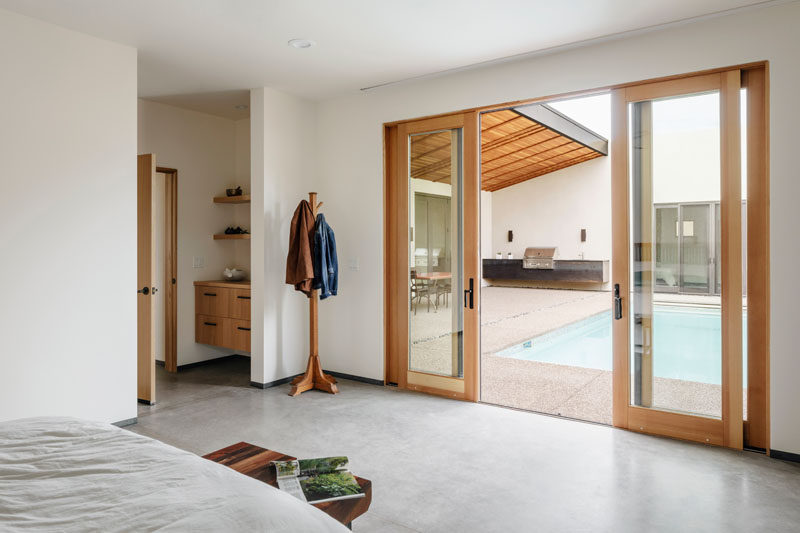 Wood-framed, sliding glass doors connect the courtyard of this modern house to the master bedroom. #SlidingGlassDoors #SlidingDoors #Doors