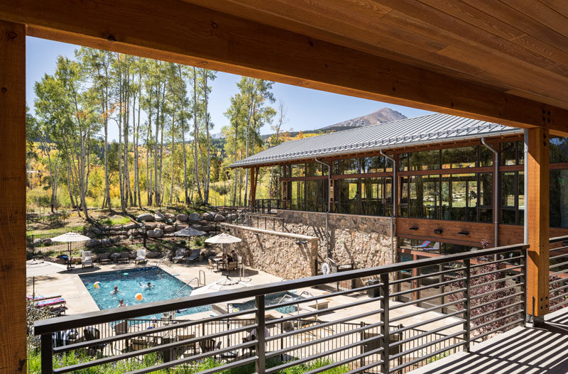 This activity center at a Colorado ranch has covered balconies that provide a view of the swimming pool, spa, and outdoor seating areas below. #SwimmingPool #StoneWalls