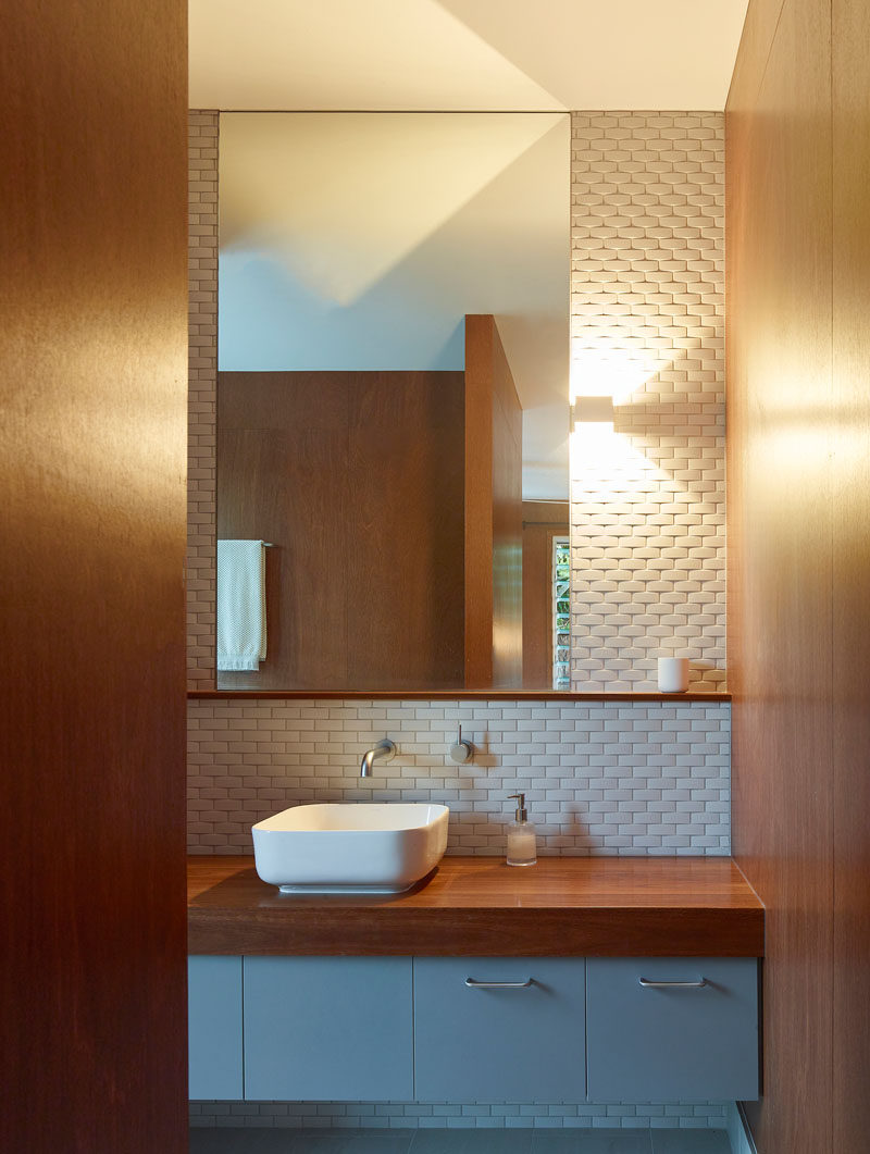 In this modern bathroom, white tile helps to keep the bathroom bright and at the same time adds texture to the wall. #BathroomDesign