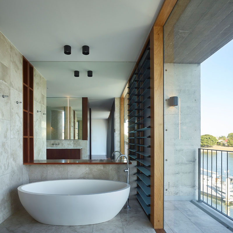 This modern bathroom has a white freestanding bathtub positioned to take advantage of the water views. #Bathroom #Bathtub