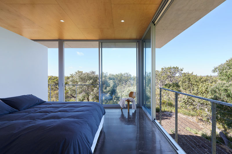 In this modern bedroom, raw galvanised steel Juliet balconies allow the floor-to-ceiling sliding glass doors to be fully opened up to the outdoors. #Bedroom #SlidingGlassDoors #JulietBalcony