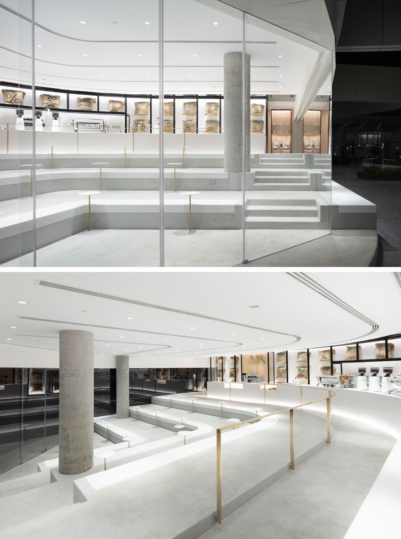 This modern and bright white coffee shop has a 4-meter ceiling height and as the location of the coffee shop is on a corner with a wide window opening, the space was designed with a layered platform gradually rising from the seating area near the entrance to the counter at the top. #ModernCoffeeShop #InteriorDesign #CoffeeShop