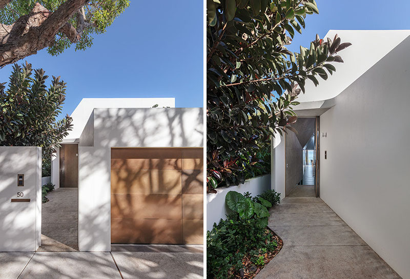 A path leads from the street to the front door of this modern white house. #Landscaping #Path