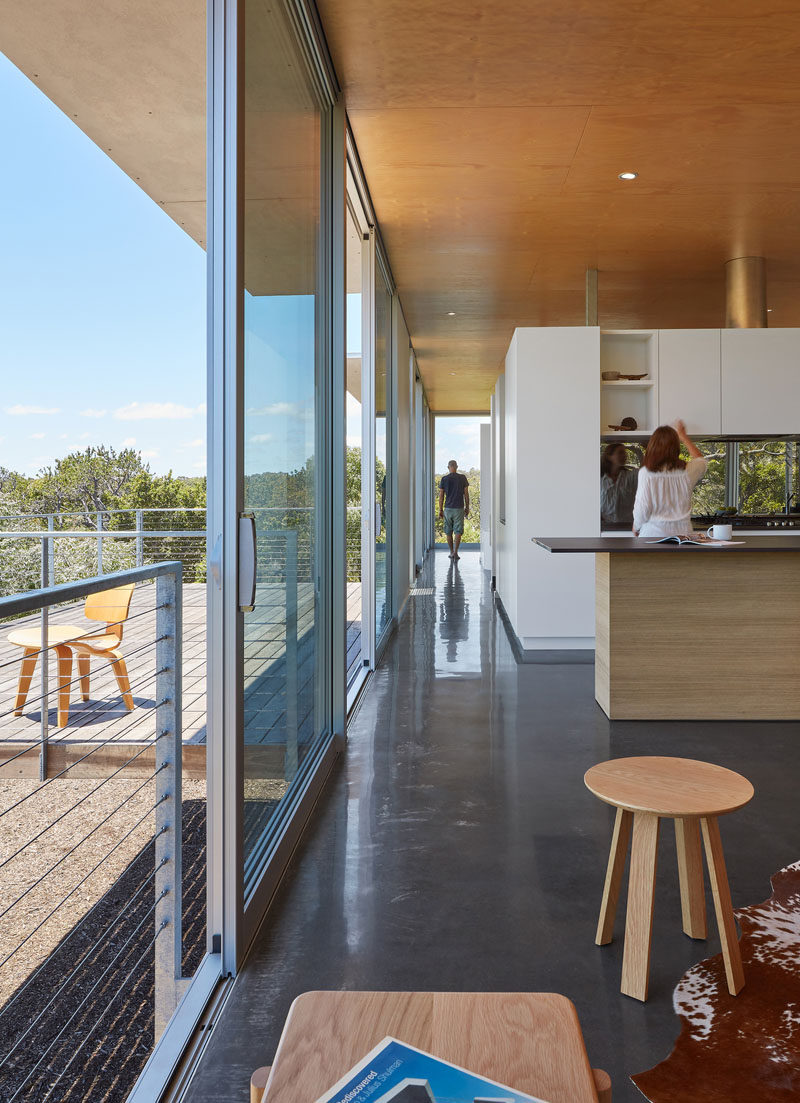 The service zone of this modern house, encompassing kitchen, laundry, bathroom and robe as well as a study are grouped in a centrally located ‘pod’, with the walls stopping short of the ceiling to enhance the visual flow of one space into another.  #Architecture #ModernHouse #InteriorDesign