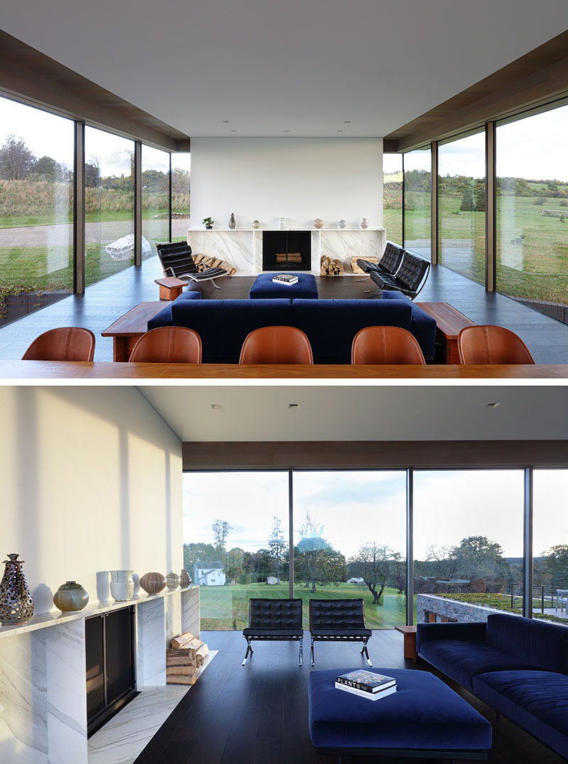 The main floor of this modern house opens up to the dining room and living room. A white wall with a fireplace and wood storage separates the living room from the entryway. #ModernLivingRoom #Fireplace