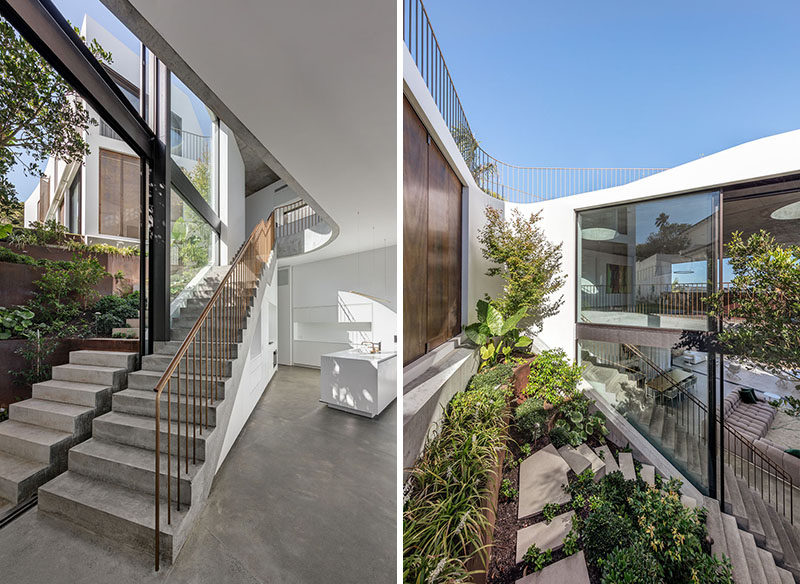 This modern house has a sloped landscape garden constructed of corten steel that provides a lush backdrop for the living spaces. #Landscaping #Garden #ConcreteStairs