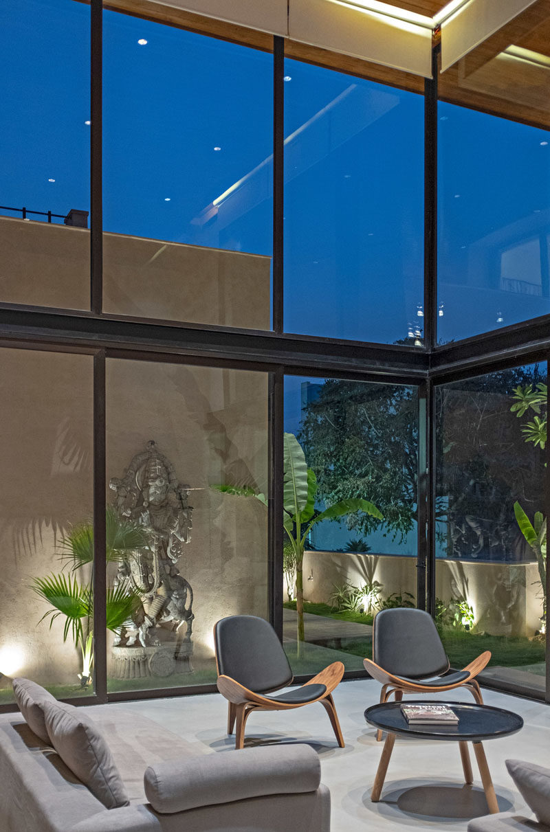 Double-height windows give this modern living room plenty of natural light, and a large sliding door opens the corner of the room to the garden. #Windows #DoubleHeightWindows