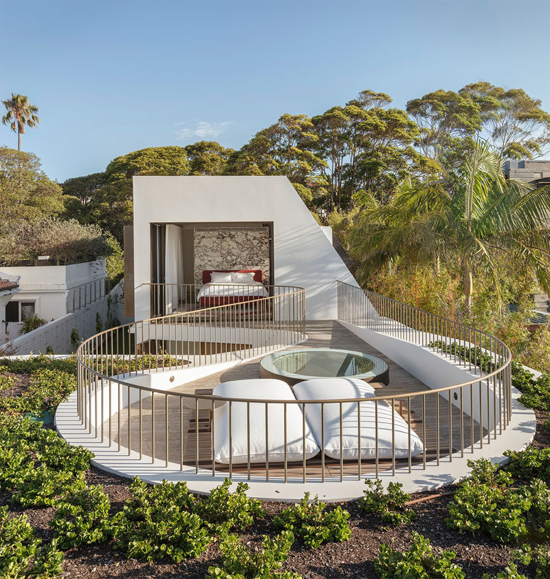 This modern house has a master suite with doors that open to a private rooftop deck surrounded by a green roof. #MasterSuite #RooftopDeck #GreenRoof