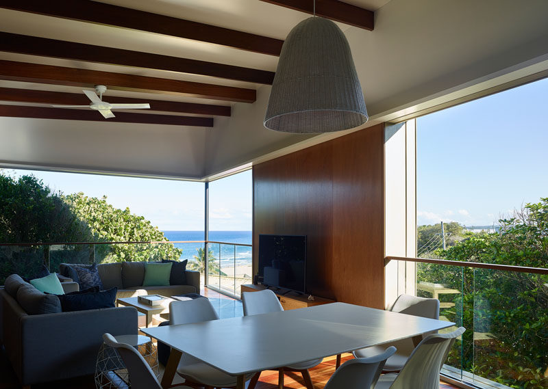 The open plan social areas of this beachside house have sweeping views of the ocean and trees. #OpenPlanInterior #LivingRoom