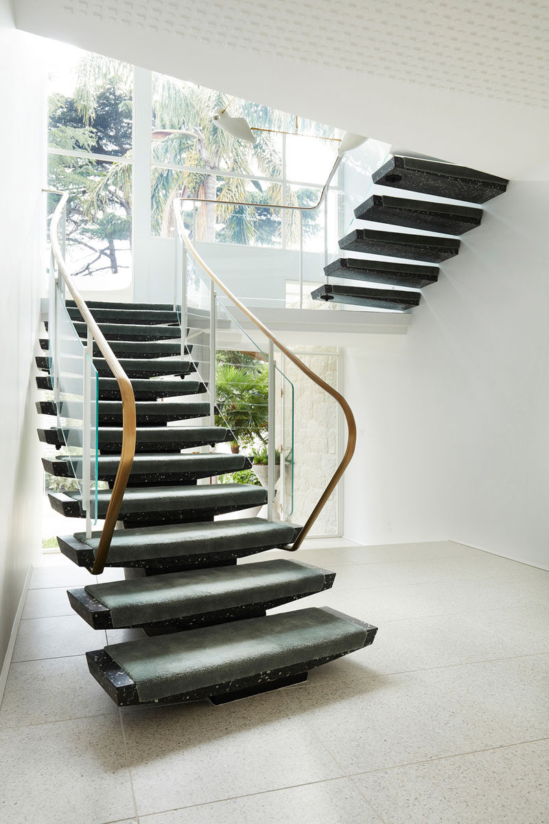 This modern house has white walls with dark stone stairs. #Stairs #StairDesign