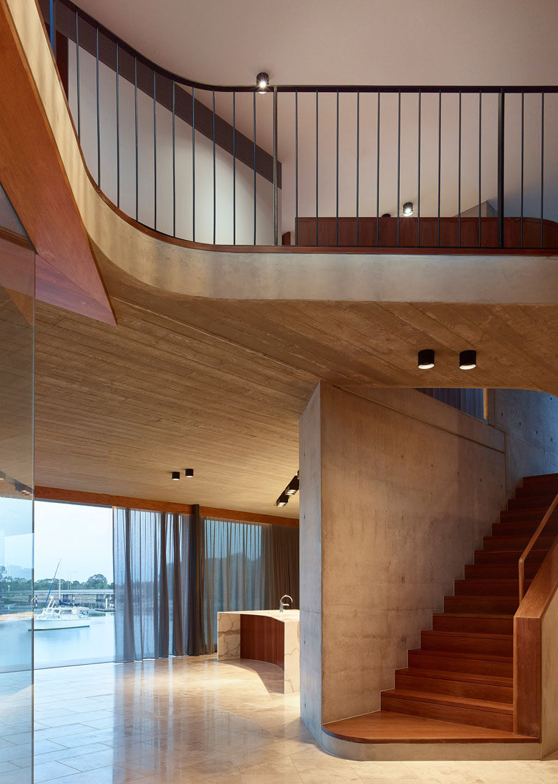 This modern house has board-formed concrete details that add texture to the interior. #WoodStairs #Concrete