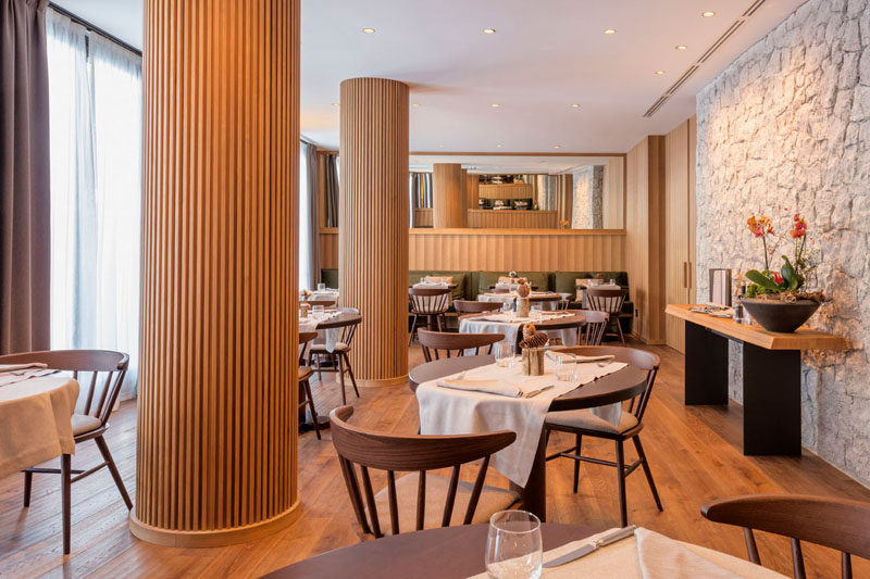 The columns in this modern restaurant's dining room have been wrapped in wood slats, hiding the column within, and turning a potential eyesore into a custom design accent. #RestaurantDesign #Columns #InteriorDesign