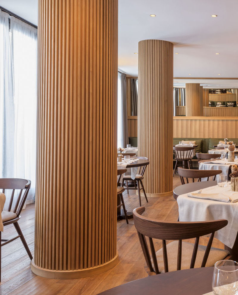 The columns in this modern restaurant's dining room have been wrapped in wood slats, hiding the column within, and turning a potential eyesore into a custom design accent. #RestaurantDesign #Columns #InteriorDesign