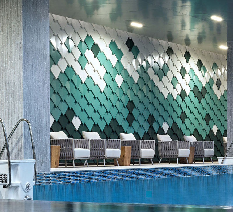 Drawing inspiration from mountains, the designers of this modern outdoor swimming pool area created a wall with custom made aluminum panels installed in a geometric formation, to create an abstract interpretation of mountain ranges. #AccentWall #SwimmingPool #AluminumPanels #MetalShingles
