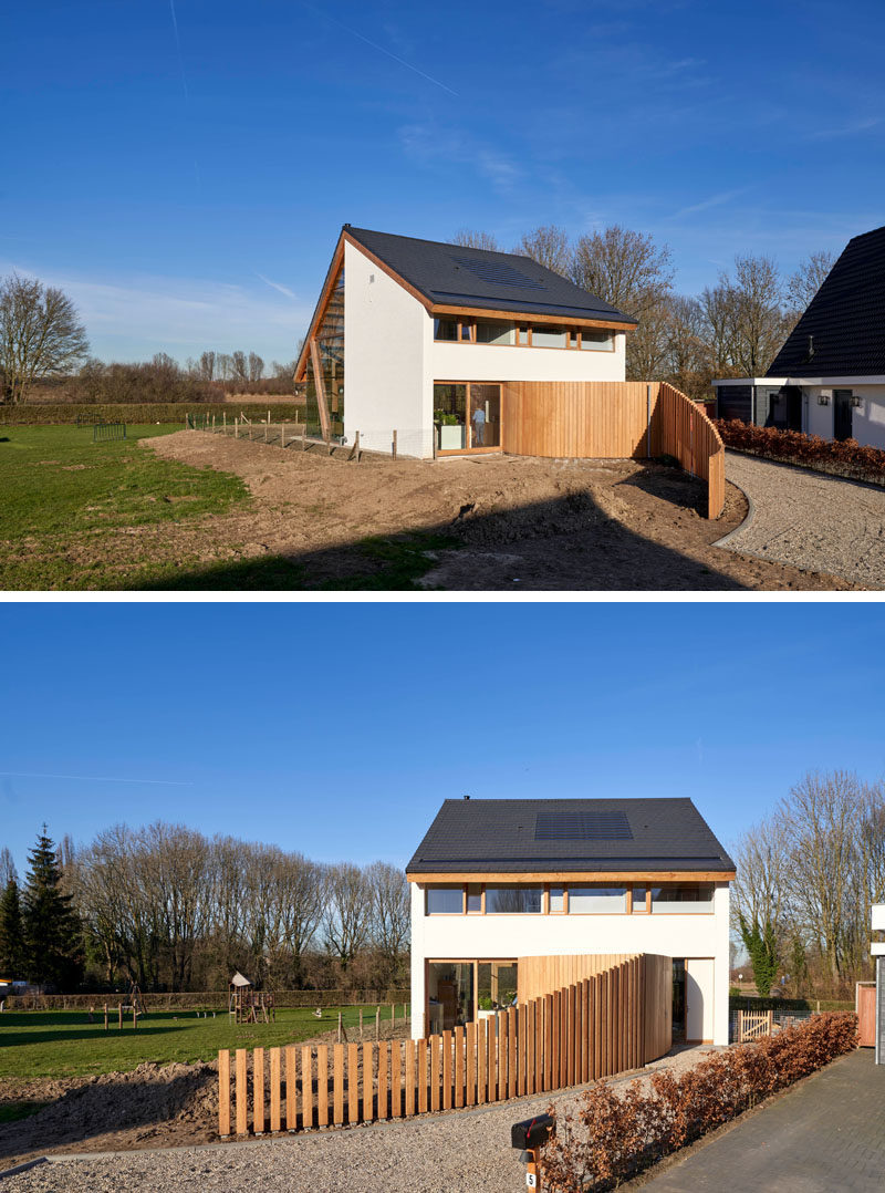 A curved fence guides visitors to the front door of this modern barn-style house. #CurvedFence