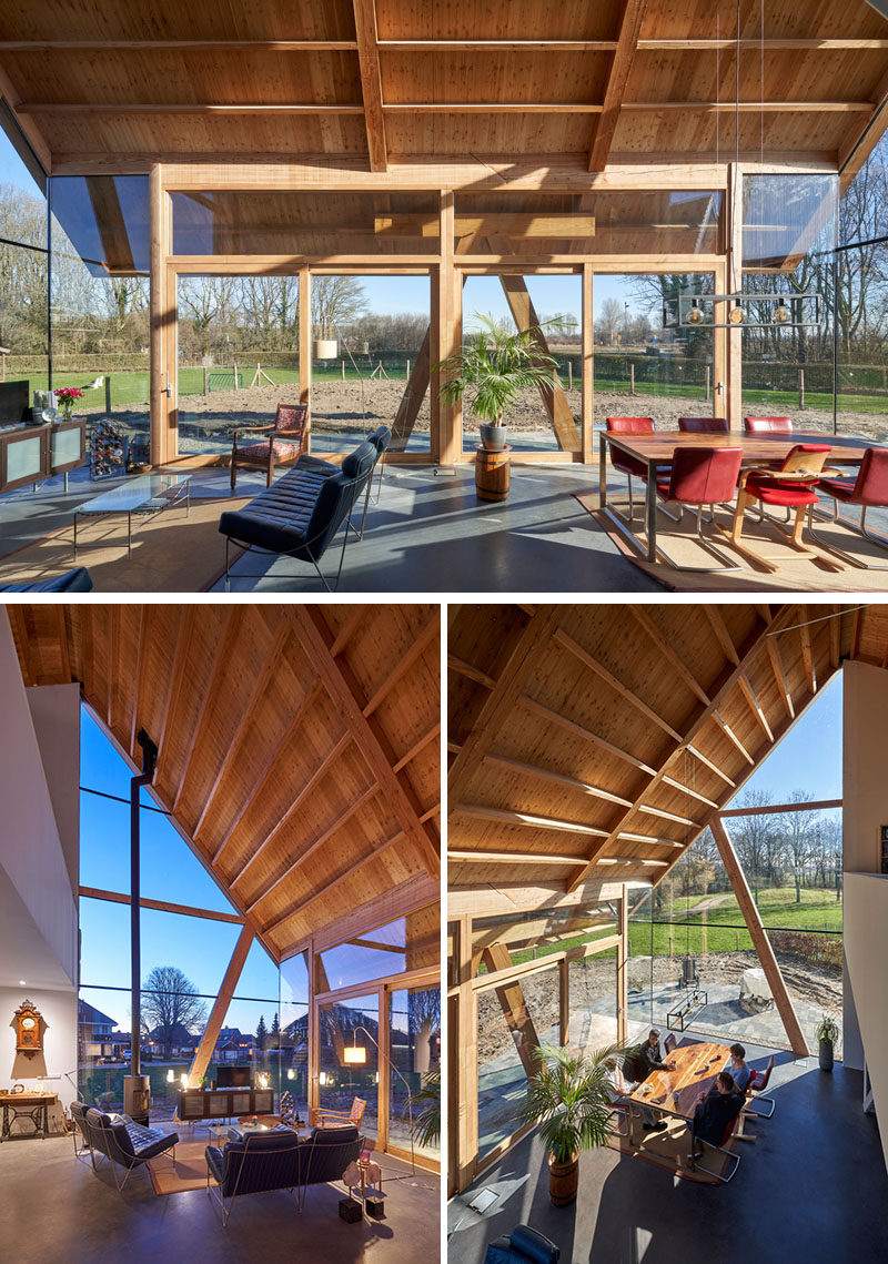 Inside this modern barn-style house, the high gable roof allows plenty of natural light to flood the interior of the home through floor-to-ceiling windows on three sides of the open plan living room and dining room. #Windows #Architecture #WoodCeiling