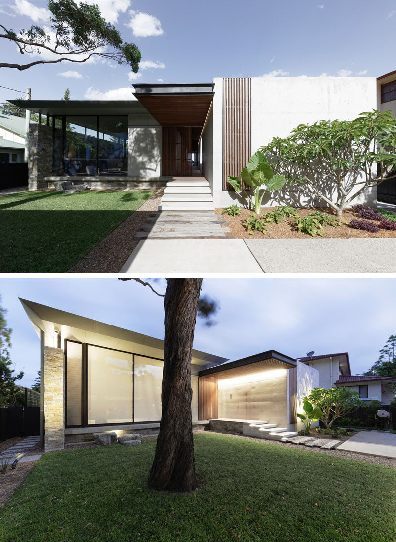 At the front of this modern beach house is a grass courtyard, and a pathway that leads to the front door. #ModernHouse #ModernArchitecture