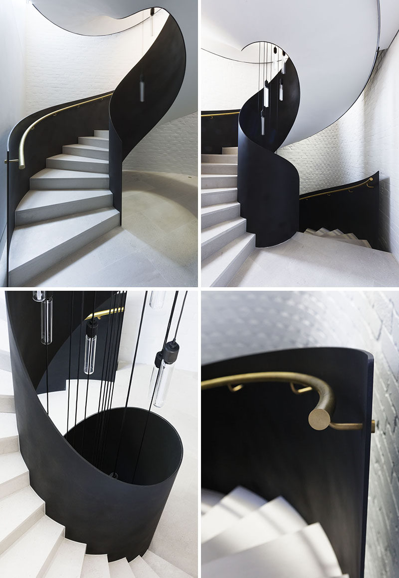 A freestanding steel plate and limestone spiral staircase leads visitors from the entryway up to the main social areas of this modern house. #SpiralStaircase #SpiralStairs