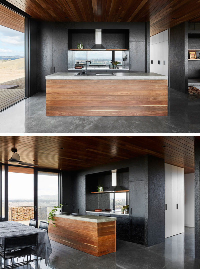 Spotted gum has been used on the ceiling and for the cabinetry throughout this modern house, while oriented strand board bracing is appropriated as wall lining and cupboard fronts. #BlackKitchen #BlackAndWood #ModernKitchen