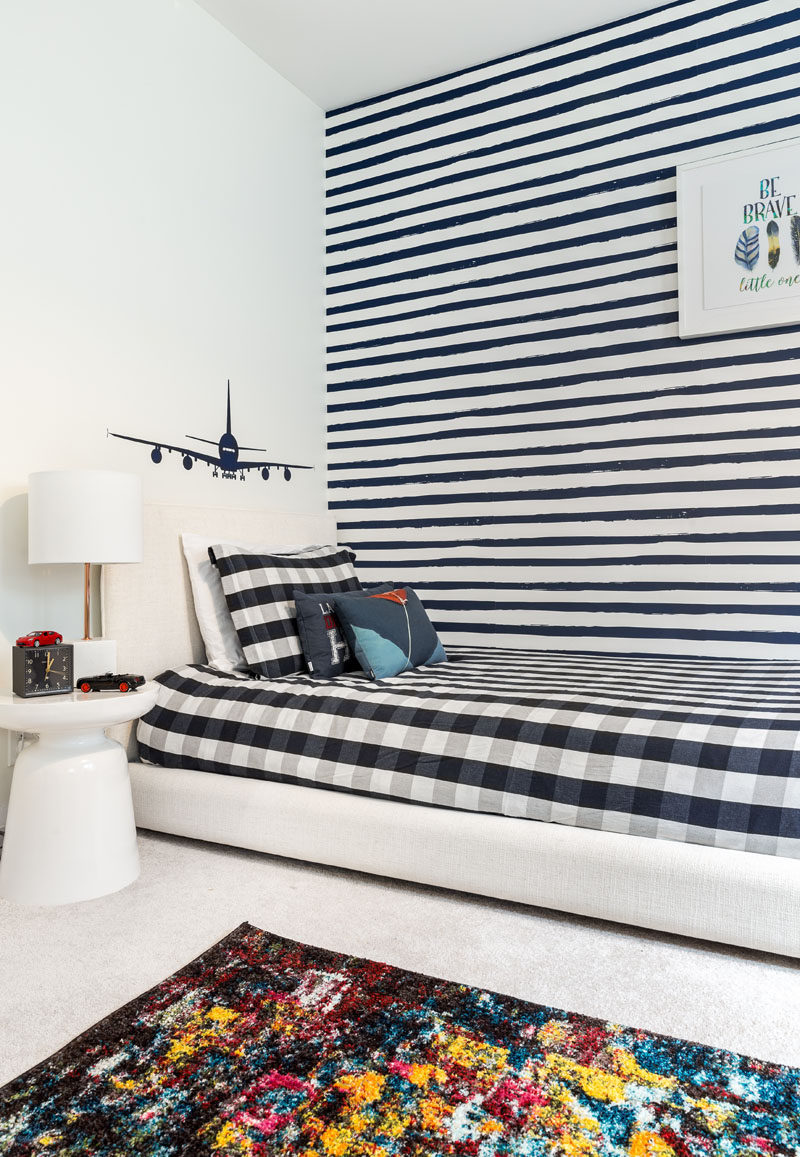 This updated modern boy's bedroom has been inspired by lived-in comfort of varsity sweats, a monochromatic palette of indigo-blues mixed with bold hints of copper, clean navy stripes, and natural tan leathers. #BoysBedroom #KidsBedroom #BedroomDesign