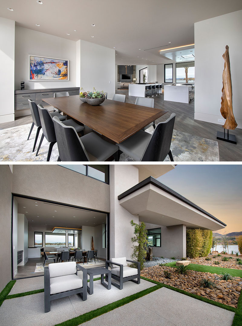 This modern dining room has a built-in floating sideboard, and opens to a small patio with a couple of armchairs. #DiningRoom #ModernDining #Landscaping