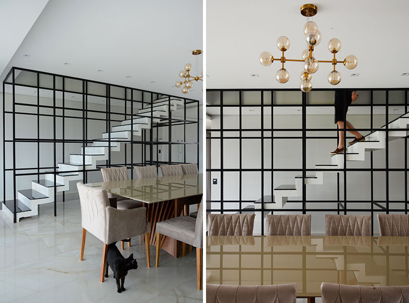 Inside this modern house and adjacent to the formal dining area, are black-framed, white stairs that lead upstairs. #Stairs #StairDesign #DiningRoom