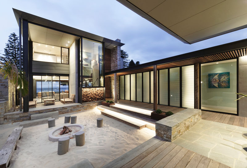 This modern house has a interior courtyard with sand and a fire pit. #FirePit #Courtyard #BeachHouse