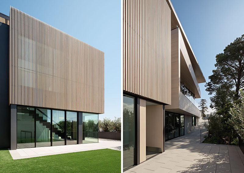 A two-story glazed volume clad in cedar slats defines the entry of this modern house. #WoodSlats #ModernHouse #Architecture