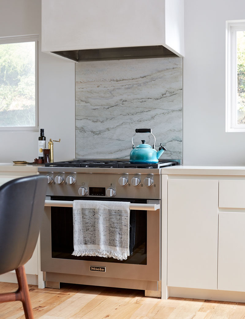 This modern kitchen has recessed finger pulls instead of traditional hardware on the cabinets have been included to keep the look modern without being too cold. #ModernKitchen #KitchenDesign #KitchenCabinets