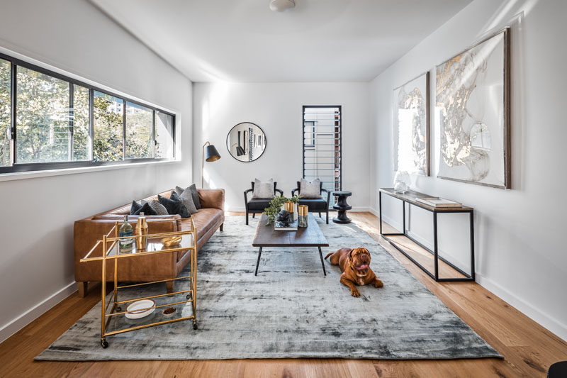 In this modern living room, a row of windows provides natural light, while louver windows allow the flow of air through the room.