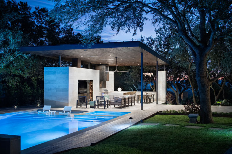 This modern steel, limestone, and wood outdoor pavilion has a living room, an outdoor kitchen with a bbq, and a dining area. #OutdoorLiving #OutdoorSpace