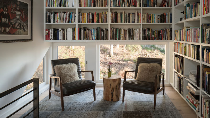 This modern house has a small library with low windows and floor-to-ceiling shelving. #SmallLibrary #Library #ReadingNook #Shelving #Windows