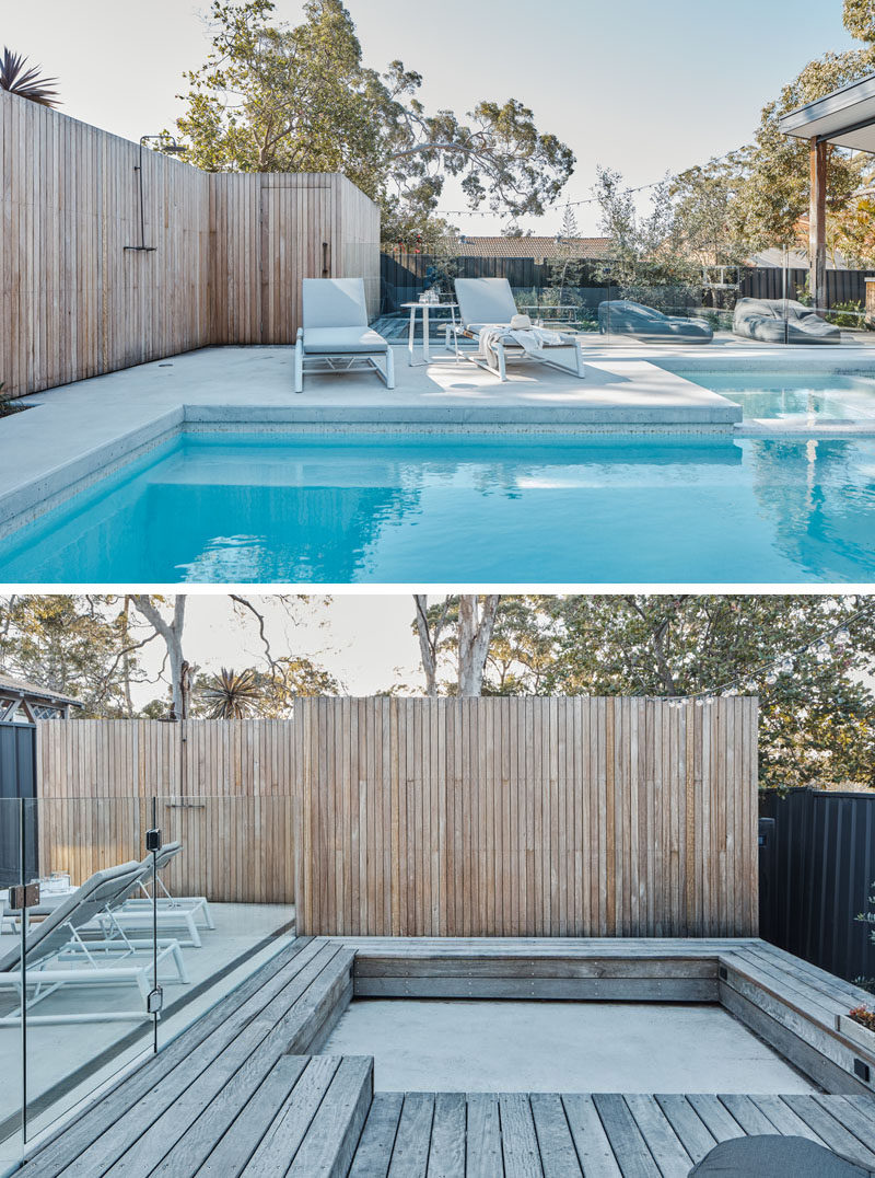 A deck with wood fencing surrounds this modern pool, while a glass safety fence almost appears invisible. A sunken seating area provides additional room for entertaining. #SwimmingPool #ModernPool #ModernDeck