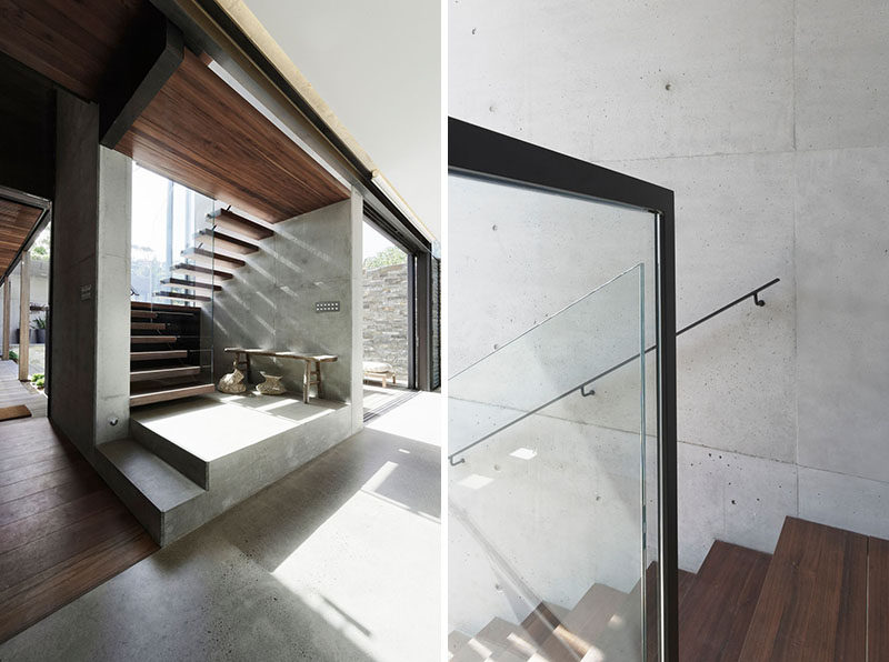 Wood and concrete stairs with a glass railing lead to the upper floor of this modern house. #Stairs #WoodStairs