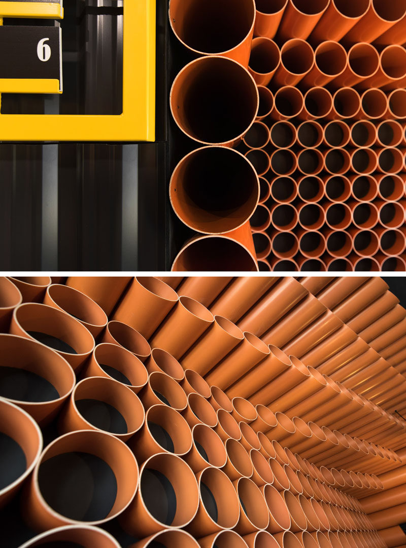 Design elements in this modern restaurant in orange PVC pipes, yellow mesh panels, dark corrugated metal sheet, wood accessories, and black tiles. #InteriorDesign #RestaurantDesign #RestaurantInterior #ModernRestaurant