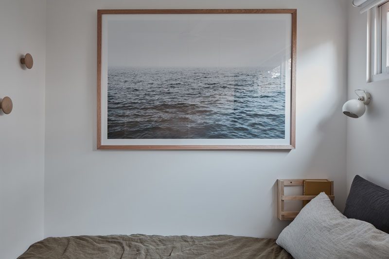 In this tiny master bedroom, furnishings have been kept minimal, and the bed tucks neatly into a niche with book racks and storage areas. #MasterBedroom #TinyHouse #SmallHouse