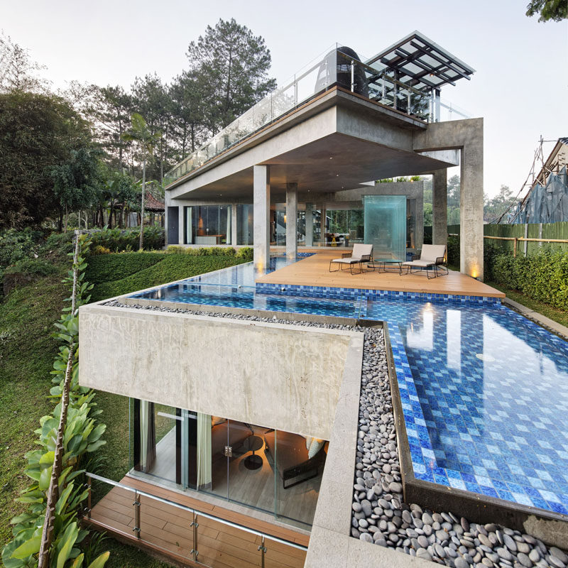 This modern house in Indonesia has been designed with full-height glass walls and a color palette that's been chosen to enhance the surrounding view.  #ModernHouse #ModernArchitecture #SwimmingPool