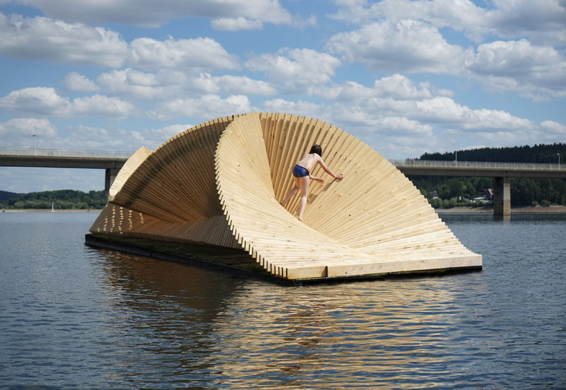 This pavilion tempts visitors with its curving forms, appearing as a solid disc when straight on, and as an ethereal and transparent screenwork from the side. #Wood #ModernDesign #Pavilion