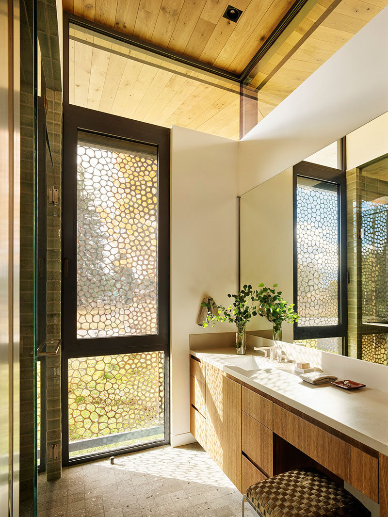 In this modern bathroom, a pierced steel curtain provides privacy without compromising the natural light. #Bathroom #PrivacyScreen