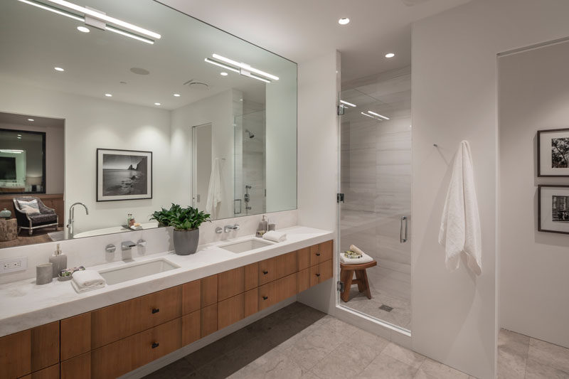 In this modern master bathroom, the Sinker Cypress has been used for the dual-sink vanity, while a glass door separates the shower from the rest of the room, and a freestanding bathtub is located opposite the vanity. #MasterBathroom #BathroomDesign #ModernBathroom