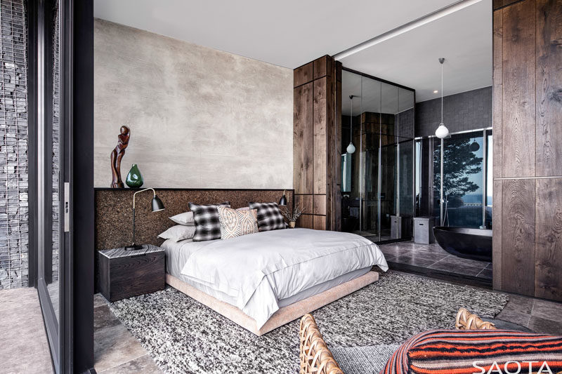 This modern bedroom features an ensuite bathroom that's open to the rest of the bedroom, allowing it to take advantage of the views. #BedroomDesign #ModernBedroom