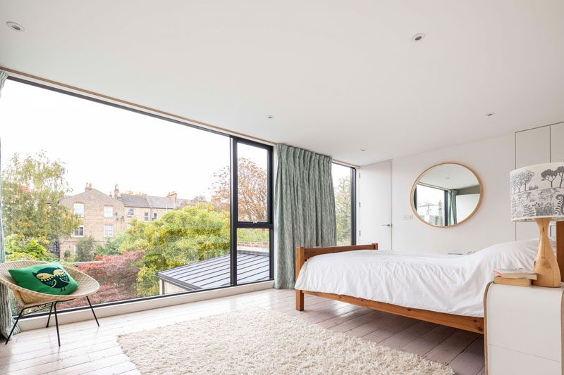 A large picture window fills this modern bedroom with natural light and frames views of the garden. #PictureWindow #ModernBedroom